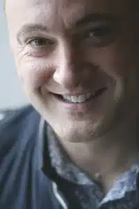 Image of Kristopher Hughes, the subject of the book review, smiling.